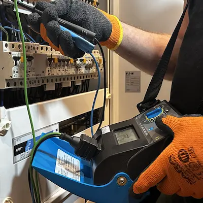 Pomiary elektryczne i przegląd techniczny skrzynki bezpiecznikowej w budynku.