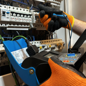 Elektryk sprawdza stan techniczny bezpieczników i przewodów w domowej rozdzielnicy elektrycznej.